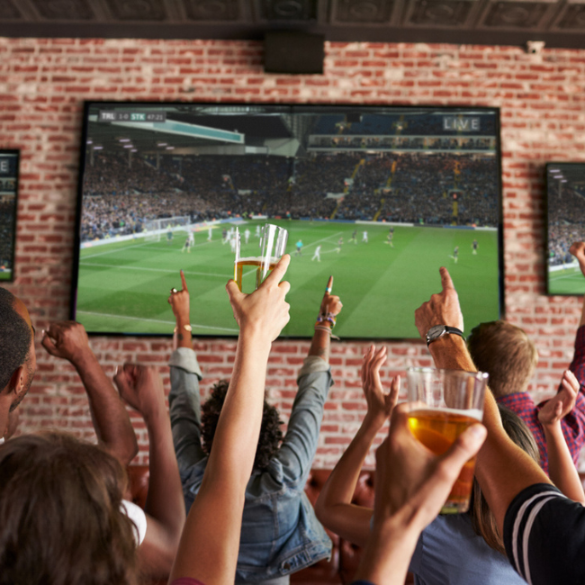 Fans cheering and watching football at 810 Entertainment